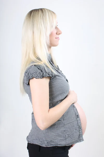 Junge schwangere Frau hält ihren Bauch — Stockfoto