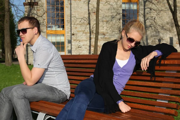 Triste pareja sentada en el parque — Foto de Stock
