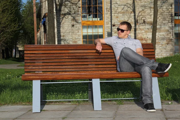 Hombre sentado en el parque en el banquillo —  Fotos de Stock