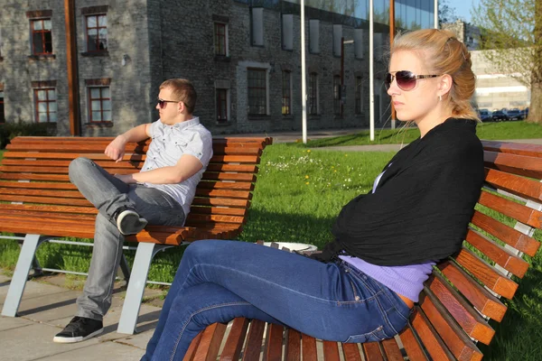 Smutny młoda para siedzi w parku — Zdjęcie stockowe