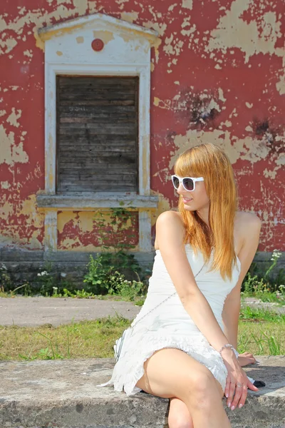 Ung kvinna på bakgrund av gamla väggen — Stockfoto