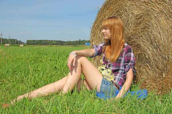Mulher em um campo com fardos de feno — Fotografia de Stock