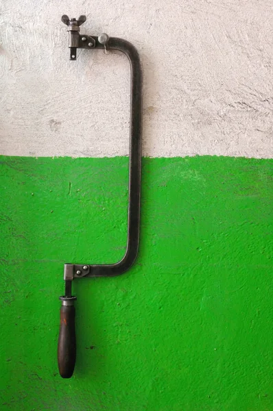 Hacksaw on obsolete wall — Stock Photo, Image
