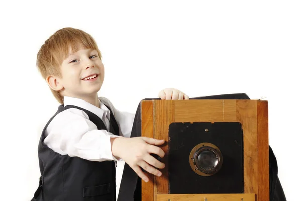 Vrolijke jongen retro fotograaf met vintage camera in studio — Stockfoto