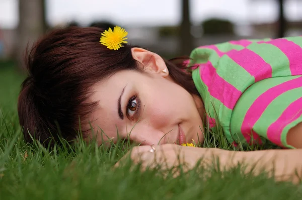 Mujer con diente de león acostada sobre hierba verde en el parque de primavera —  Fotos de Stock