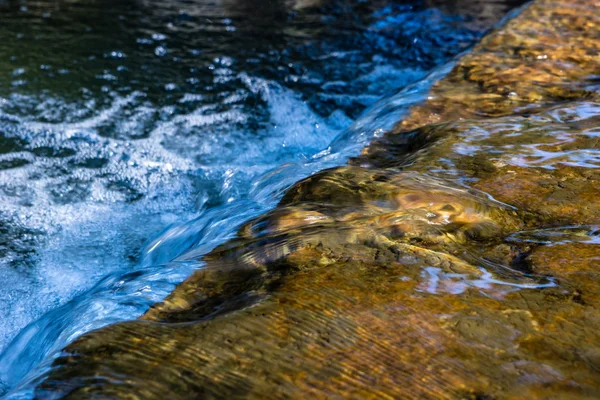 Um pequeno riacho com uma cachoeira Fotografia De Stock