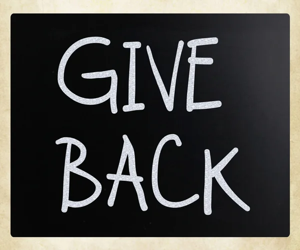 "Give back "handwritten with white chalk on a blackboard — стоковое фото