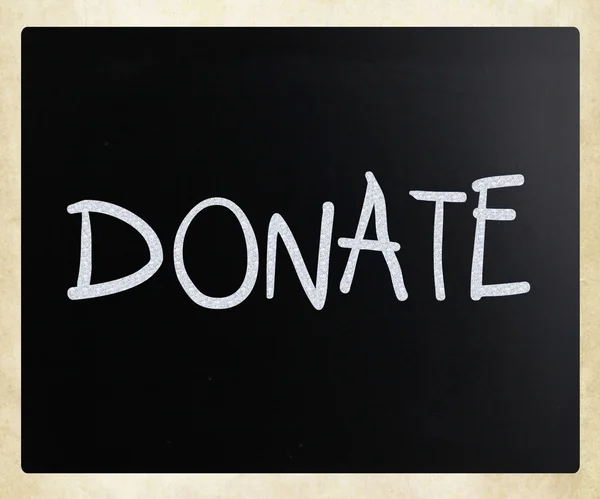 "Donate "handwritten with white chalk on a blackboard — стоковое фото