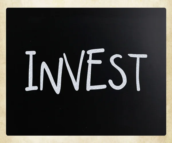 "invest "handgeschrieben mit weißer Kreide auf einer Tafel — Stockfoto