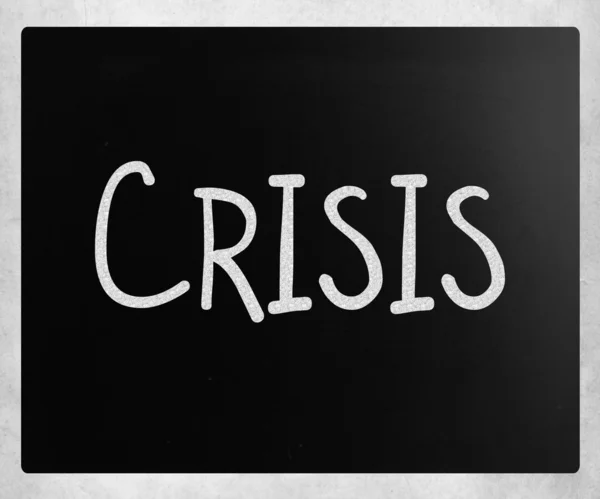 ""危机" 用白色粉笔在黑板上手写 — 图库照片