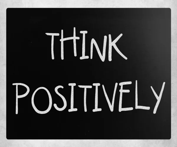 "Myslet pozitivně"rukou s bílou křídou na tabuli — Stock fotografie