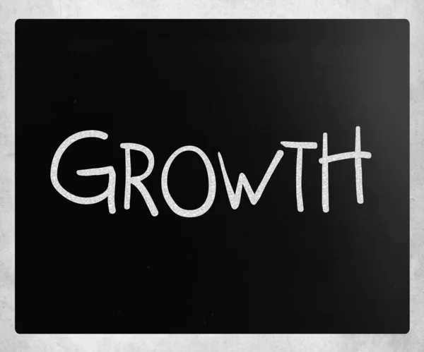 "Růst"v rukou s bílou křídou na tabuli — Stock fotografie