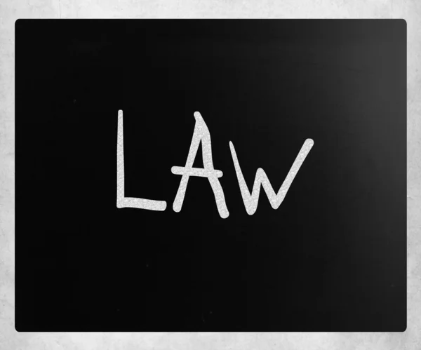 "Zákon"v rukou s bílou křídou na tabuli — Stock fotografie