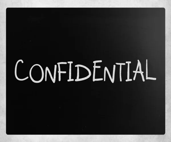 The word "Confidential" handwritten with white chalk on a blackb — Stock Photo, Image