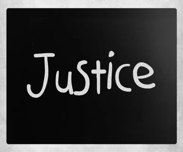 用白色粉笔在黑板上手写的"正义"这个词 — 图库照片