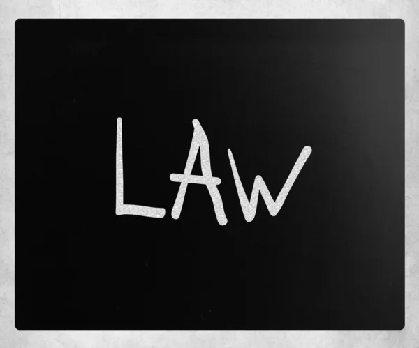 Слово "закон" написано от руки белым мелом на доске — стоковое фото