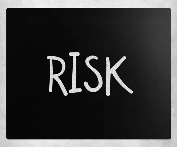 A "kockázat" fehér krétával egy táblára kézzel írott szó — Stock Fotó