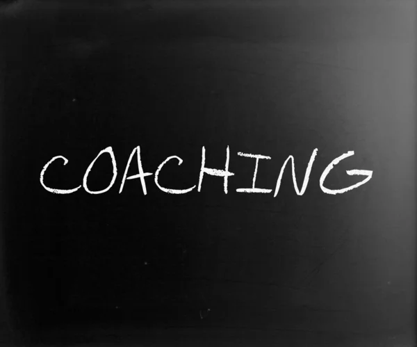 "Coaching "handskriven med vit krita på en svart tavla — Stockfoto