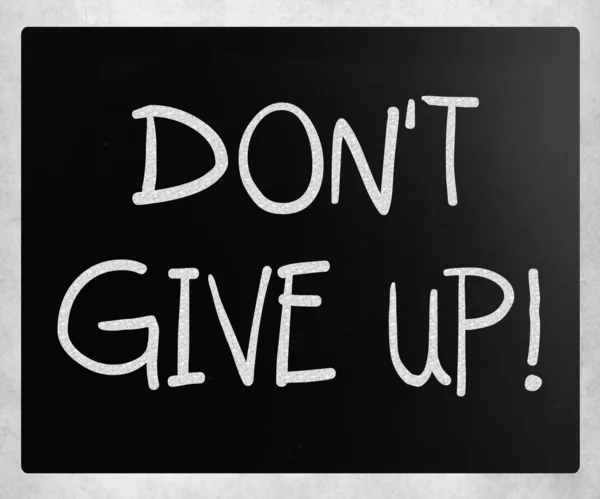 "Ne pas abandonner "écrit à la main avec de la craie blanche sur un tableau noir — Photo