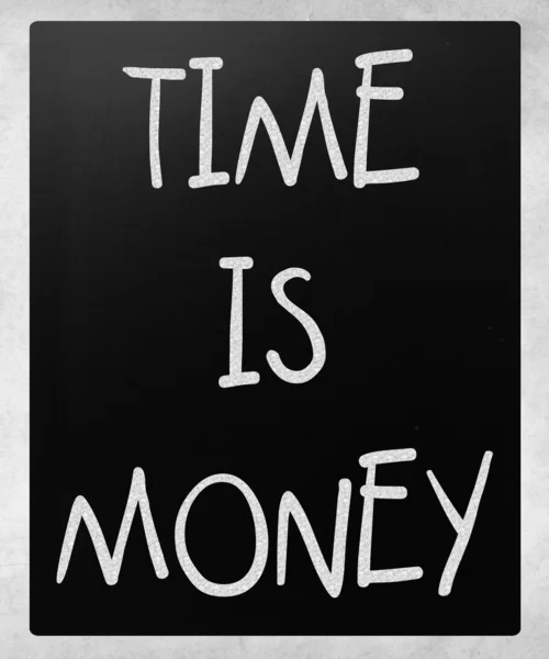 "Time is money "handwritten with white chalk on a blackboard — стоковое фото