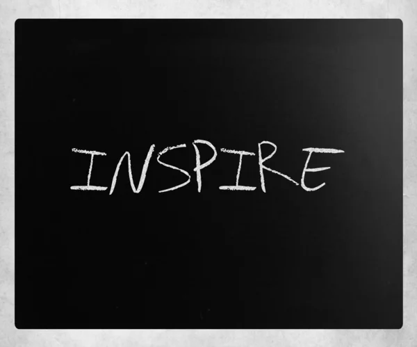 "Inspireer "handgeschreven met wit krijt op een Blackboard — Stockfoto