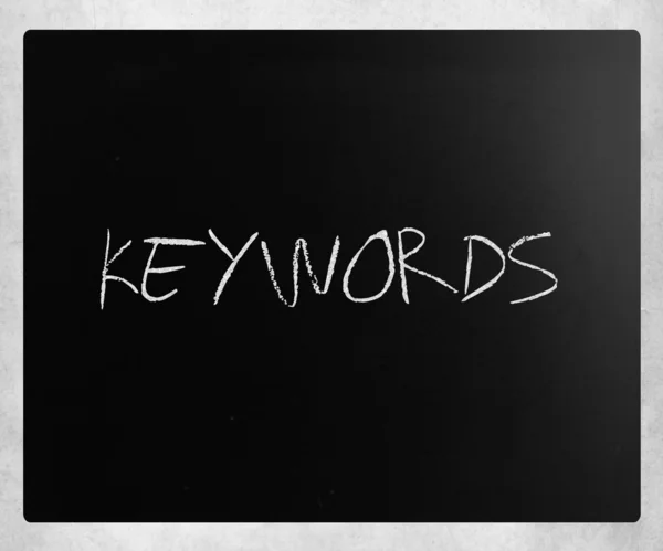 A "Kulcsszavak" fehér krétával egy táblára kézzel írott szó — Stock Fotó