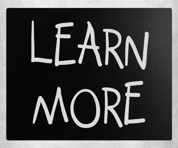 "Learn More" handwritten with white chalk on a blackboard — Stock Photo, Image