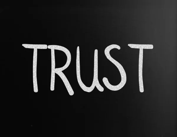 Η λέξη "εμπιστοσύνη" χειρόγραφα με άσπρη κιμωλία σε έναν πίνακα — Φωτογραφία Αρχείου