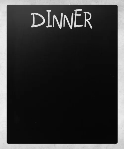 "Dinner "handwritten with white chalk on a blackboard — стоковое фото