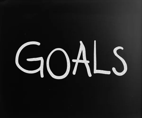 A "célok" fehér krétával egy táblára kézzel írott szó — Stock Fotó