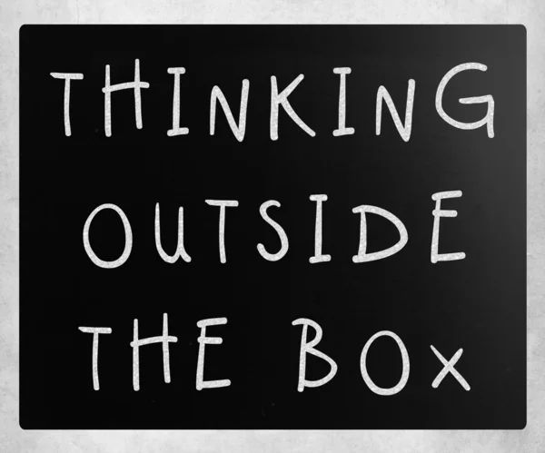 Thinking outside the box phrase, handwritten with white chalk on — Stock Photo, Image