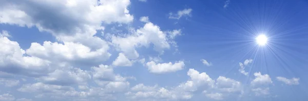 Blauwe lucht met zon en mooie wolken — Stockfoto