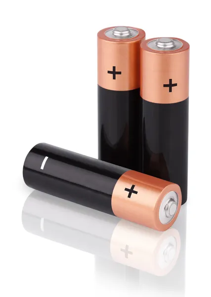 Närbild av tre aa-batterier på vit — Stockfoto