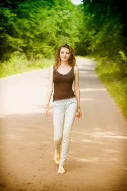 Young woman walking in the countryside clipart