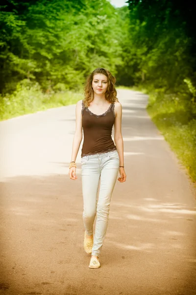 Jovem mulher caminhando no campo — Fotografia de Stock