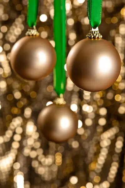 Üç Altın christmas baubles altın parıltı backgr önünde — Stok fotoğraf