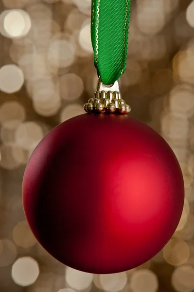 Egyetlen karácsonyi csecsebecse, csillogó arany háttér előtt — Stock Fotó