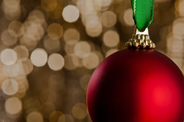 Single Christmas bauble in front of a gold glitter background — Stock Photo, Image