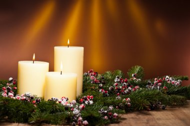 Three candles in an advent flower arrangement clipart