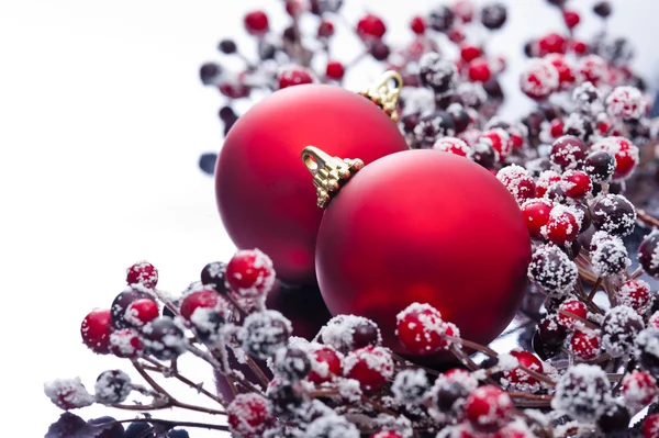 Two Christmas baubles and holly berries — Stock Photo, Image