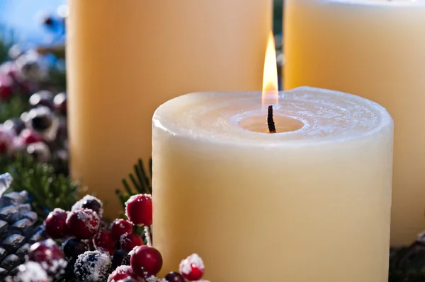 Drei brennende Kerzen in einem adventlichen Gesteck — Stockfoto