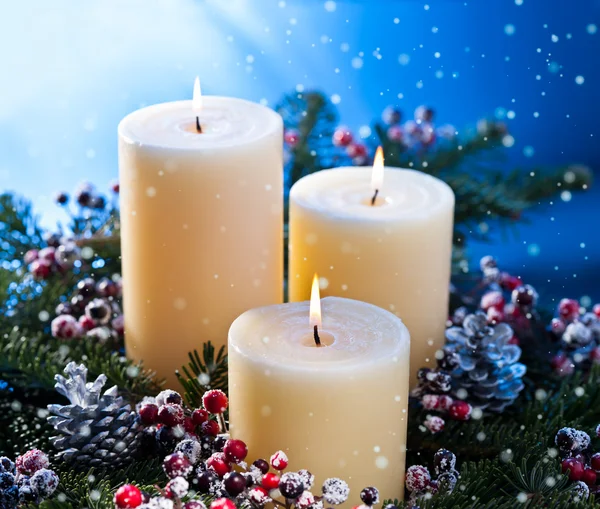 Stock image Three candles with snowfall