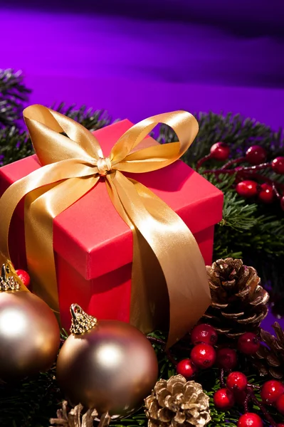 Caixa de presente vermelho em um cenário de Natal roxo — Fotografia de Stock