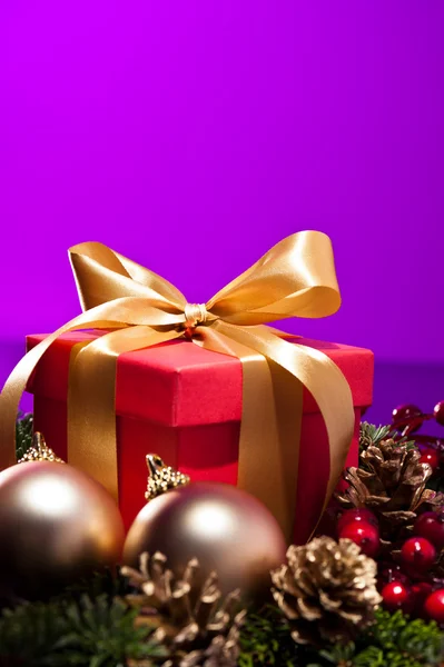 Caja de regalo roja en un ajuste de Navidad púrpura — Foto de Stock