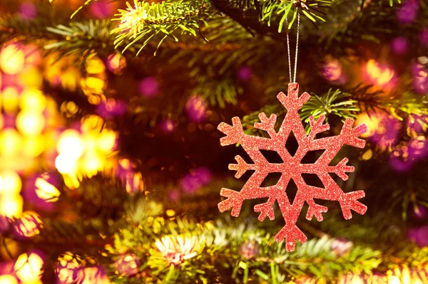 Fiocco di neve rosso in un albero di Natale con colori al neon — Foto Stock