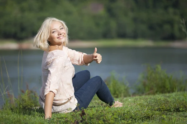 Portrait of young happy woman giving thumb up — Stock Photo, Image