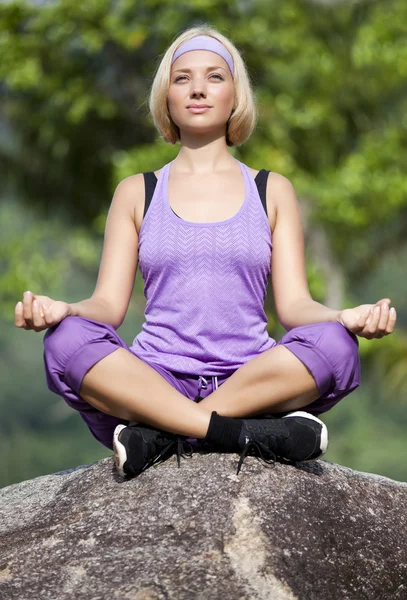 Yoga-Frau auf dem Stein, Natur lizenzfreie Stockbilder