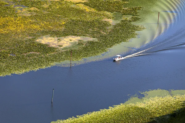 Łódź płynie wzdłuż rzeki przez — Zdjęcie stockowe