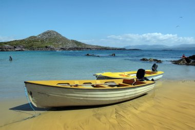 Yellow boats on golden irish beach clipart