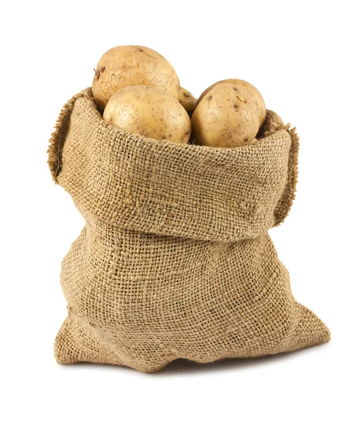 Patatas crudas en saco de arpillera — Foto de Stock